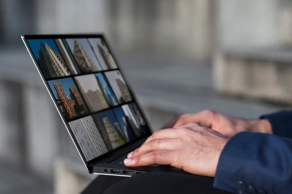 Close-up of a person using a laptop displaying architectural images